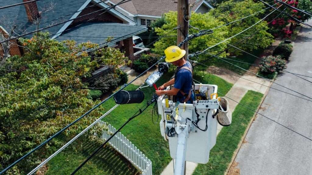 Electrician in a bucket lift repairing power lines